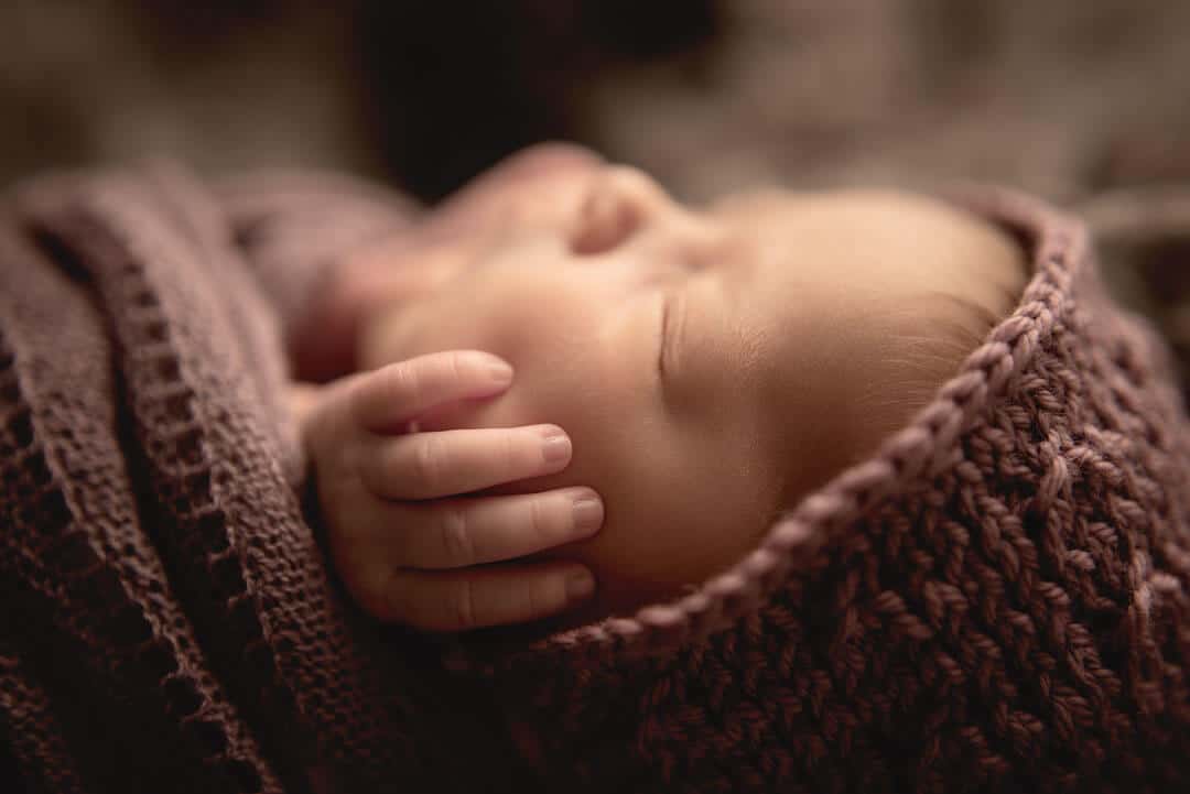 newborn sleeping with hands on cheeks.  iris lane photography akron canton green hartville ne ohio