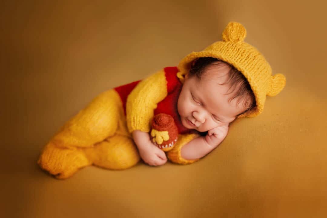 newborn baby dressed in pooh bear outfit. iris lane photography akron canton green hartville ne ohio