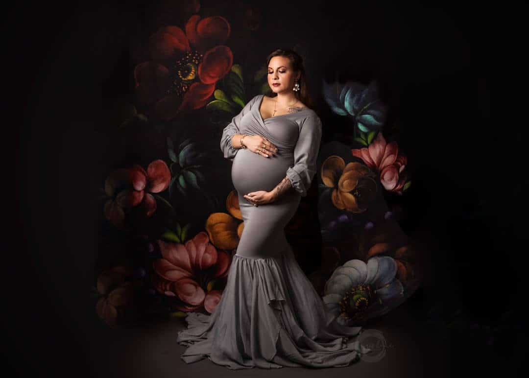 pregnant woman studio session gray dress floral backdrop. iris lane photography maternity photo akron canton ohio