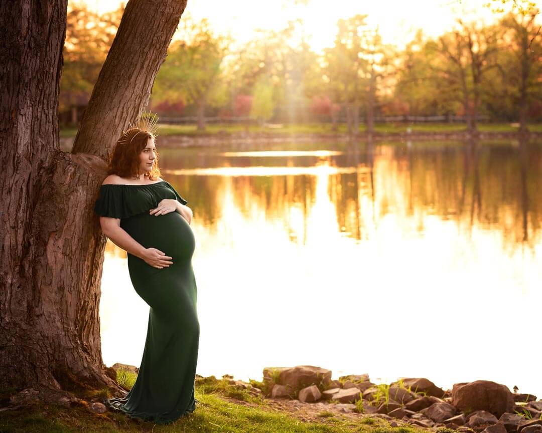 Pregnant woman hands on belly standing on lake shore at sunset..  Iris Lane Photography Akron Canton Cleveland Youngstown NE OHIO maternity newborn photographer