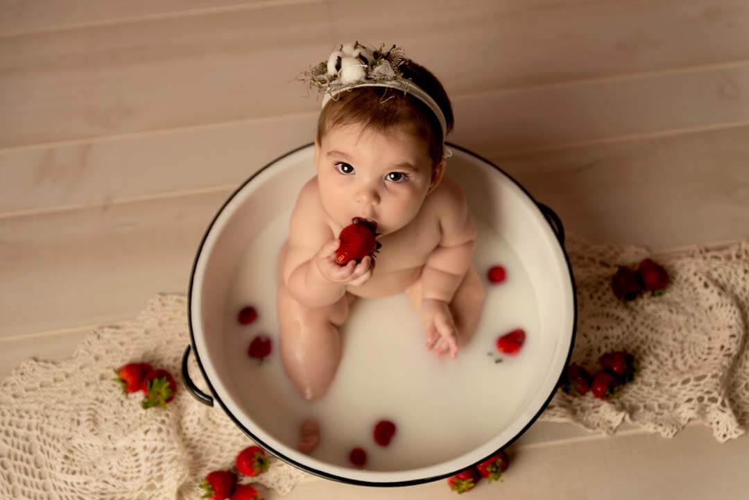 toddler girl in milk bath with strawberries.  iris lane photography akron canton green hartville ne ohio